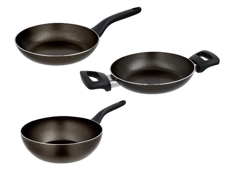 Trois poêles antiadhésives noires avec poignées, dont une avec deux poignées courtes.