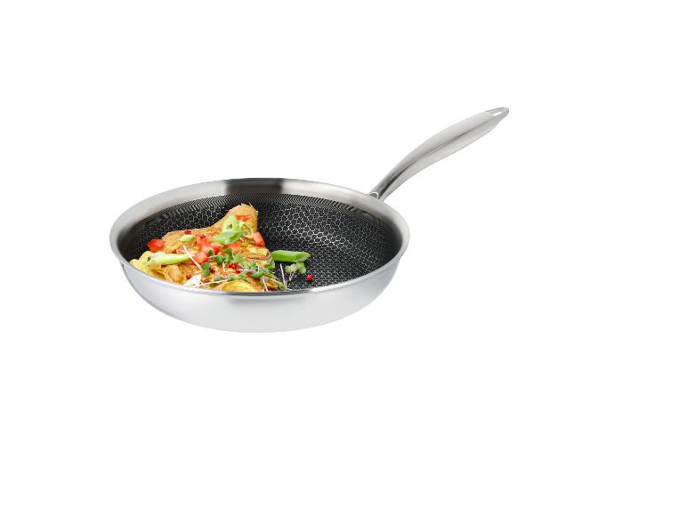 Poêle en acier inoxydable avec omelette et légumes.