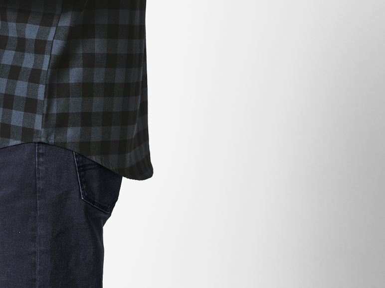 Chemise à carreaux bleu marine et noire sur un jean foncé.