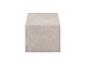 Un bloc de marbre beige avec des veines blanches, vu d'une perspective légèrement élevée.