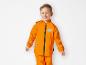 Un garçon portant un imperméable orange avec un éléphant.