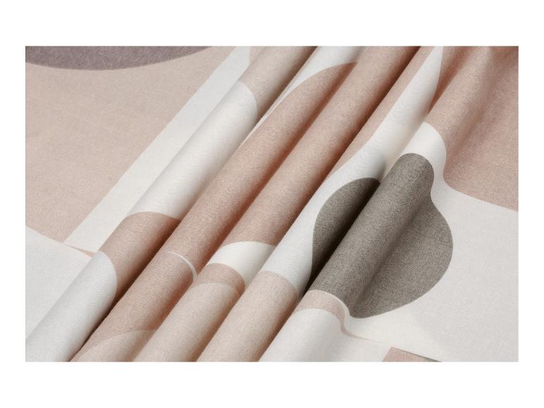 Tissu plié avec un motif de cercles et de lignes dans des tons beige, marron et blanc.