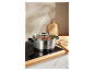 Une casserole en acier inoxydable avec de la nourriture qui cuit sur une plaque à induction.