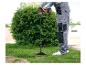 Un homme utilise une perceuse Parkside avec une tarière dans le jardin.
