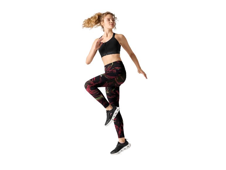 Femme en brassière de sport noire et leggings à motifs faisant de l'exercice.