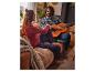 Un homme et une femme en pyjama sur le canapé, il joue de la guitare.