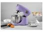 Un batteur sur socle Bergner violet avec un bol, un fouet et des cupcakes sur un support blanc.