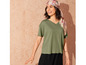 Une femme porte un t-shirt vert à col en V et une écharpe à imprimé floral.
