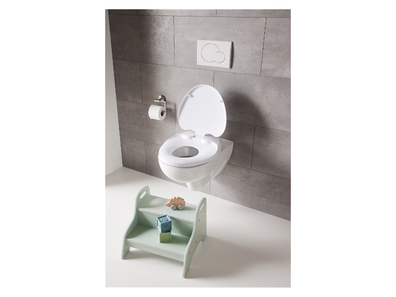 Réducteur de toilette pour enfant et jouets sur un tabouret.