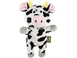 Peluche vache en noir et blanc avec des cornes jaunes et un nez rose.