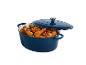 Cocotte ovale bleue avec poulet rôti et légumes, couvercle entrouvert.