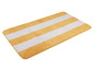 Un tapis de bain jaune et blanc à rayures.