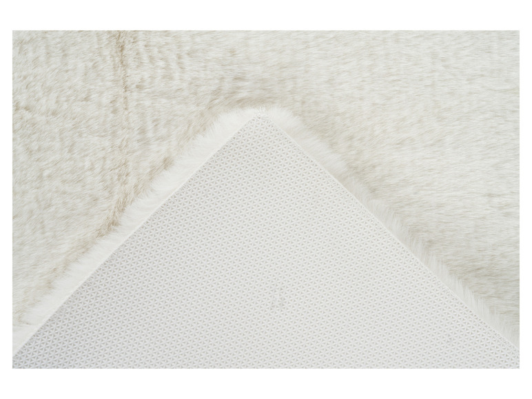 Un tapis blanc avec un dessous lisse.