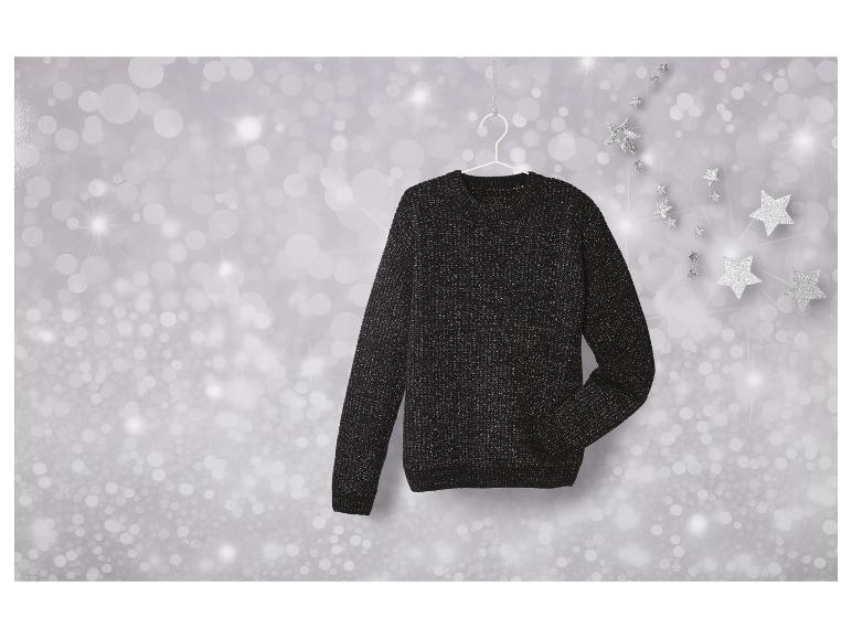 Un pull noir à paillettes suspendu à un cintre blanc sur un fond d'étoiles argentées.