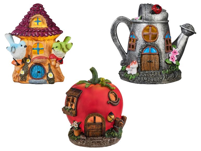 Trois maisons de jardin féeriques fantaisistes : une souche d'arbre, un arrosoir et une tomate.