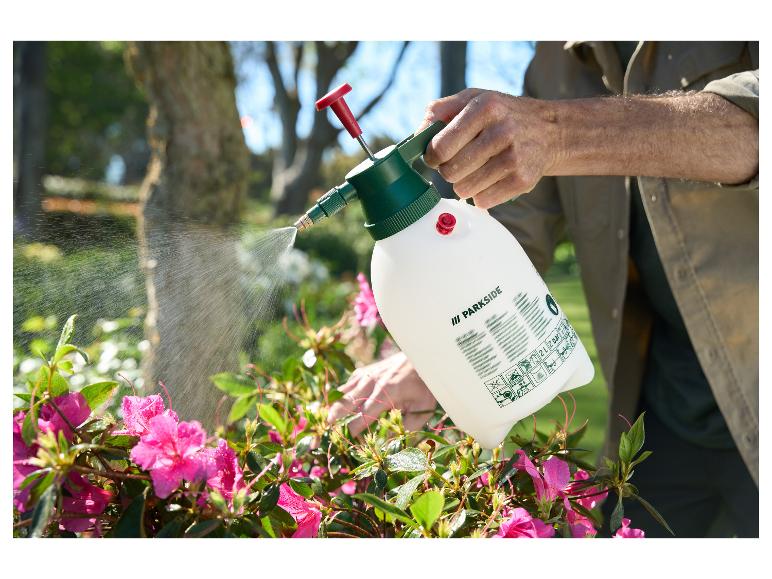 Homme arrosant des fleurs roses avec un pulvérisateur Parkside