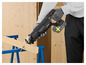 Une personne utilise une scie Parkside X20V Team pour couper du bois.