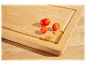 Tomates coupées sur une planche à découper en bambou.