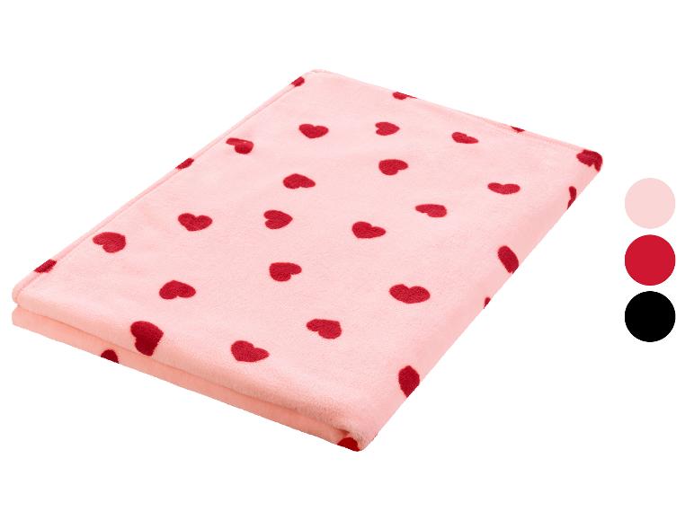 Une couverture rose avec des cœurs rouges