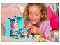Une fille joue avec une maison de poupée et des poupées de la série 'Paws & Pals'.