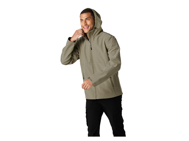 Homme en veste à capuche vert clair et pantalon cargo noir, souriant.