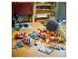 Enfant construisant un train et des rails LEGO City sur une table en bois.