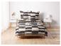 Un lit avec une couette rayée en gris foncé, beige et blanc