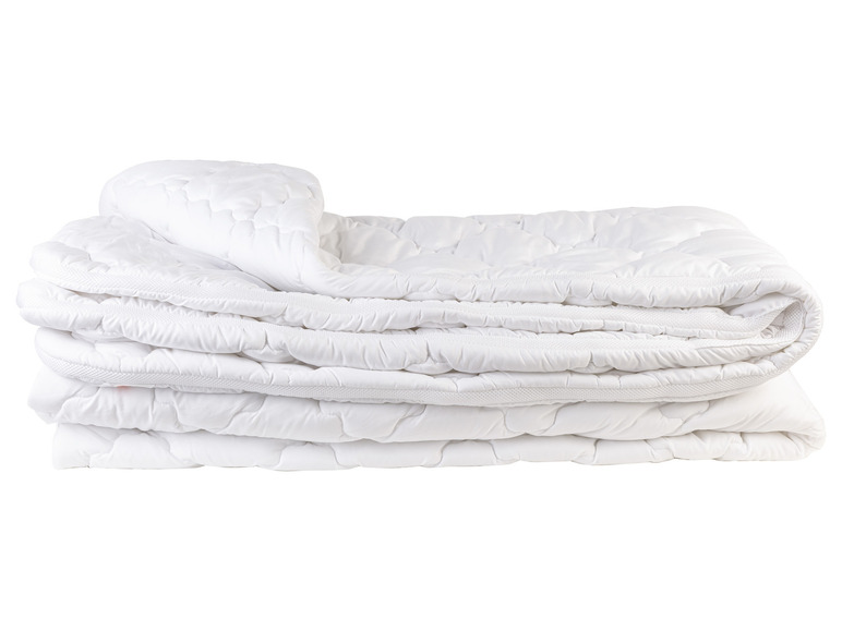 Une couette blanche matelassée, pliée.