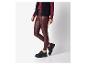 Femme portant un legging en simili cuir bordeaux et des chaussures noires.