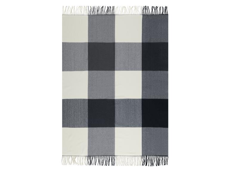 Couverture à carreaux de buffle en blanc, gris clair et gris foncé avec bords frangés.