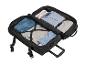 Une valise noire à roulettes remplie de vêtements et de chaussures.