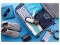 Valise ouverte avec vêtements, chaussures, lunettes de soleil et aspirateur à main, prête pour le voyage.