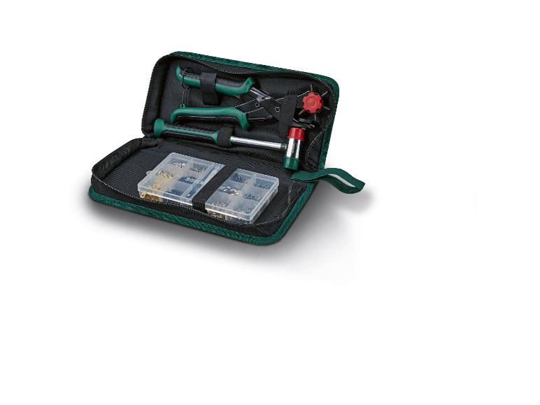 Kit d'outils vert avec pince, marteau et petites pièces dans une mallette.