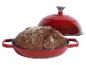 Pain cuit dans une cocotte en fonte rouge avec le couvercle à côté