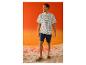Homme souriant en t-shirt rayé ESMARA MEN et short sur la plage.
