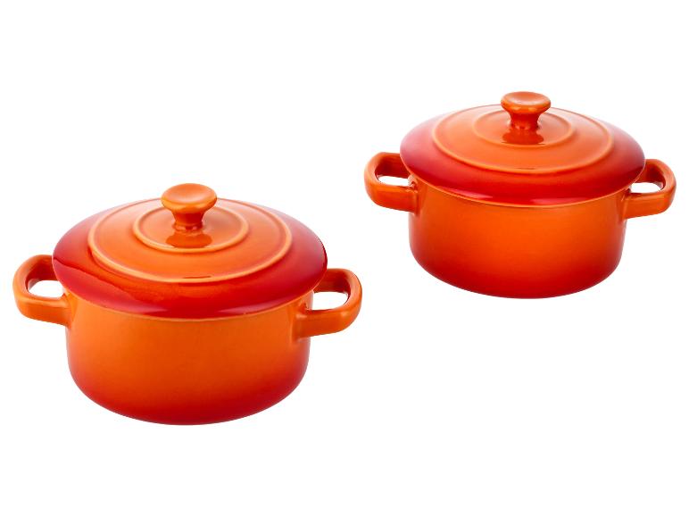 Deux cocottes en céramique orange vif avec couvercles et poignées.