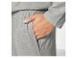Pantalon de survêtement gris avec une main dans la poche.