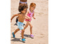 Deux enfants en maillot de bain courent sur la plage.