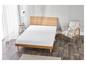 Un matelas blanc sur un cadre de lit en bois dans une chambre à coucher.