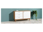Une commode blanche avec trois tiroirs et une porte, sur un tapis dans un intérieur moderne.