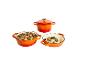 Trois cocottes en fonte émaillée orange, dont deux remplies de plats cuisinés.