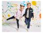 Gilets matelassés et jeans pour enfants, près d'un mur peint.