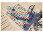 Une couverture de pique-nique Mickey Mouse avec un sac assorti sur la plage.