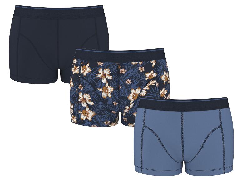 Trois boxers en coton pour hommes : un bleu marine, un à motif floral et un bleu clair.