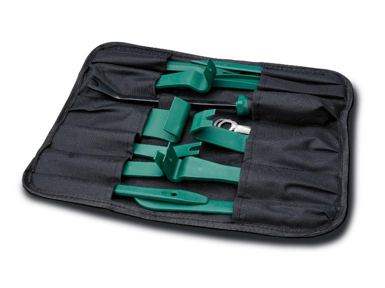 Trousse à outils noire enroulable avec des outils verts de démontage de garnitures et une clé à œil métallique.