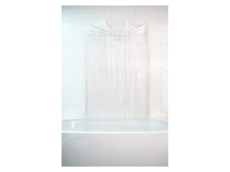 Un rideau de douche transparent en plastique avec un support en métal dans une baignoire blanche.