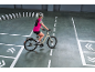 Femme sur un vélo électrique sur un parcours d'entraînement avec des cônes blancs.