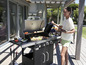 Une femme sert de la nourriture grillée d'un barbecue à gaz Grillmeister.