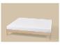 Sommier en bois avec matelas blanc sur fond beige
