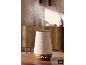 Diffuseur d'huiles essentielles en bois et tissu, avec de la vapeur, sur une table en bois.